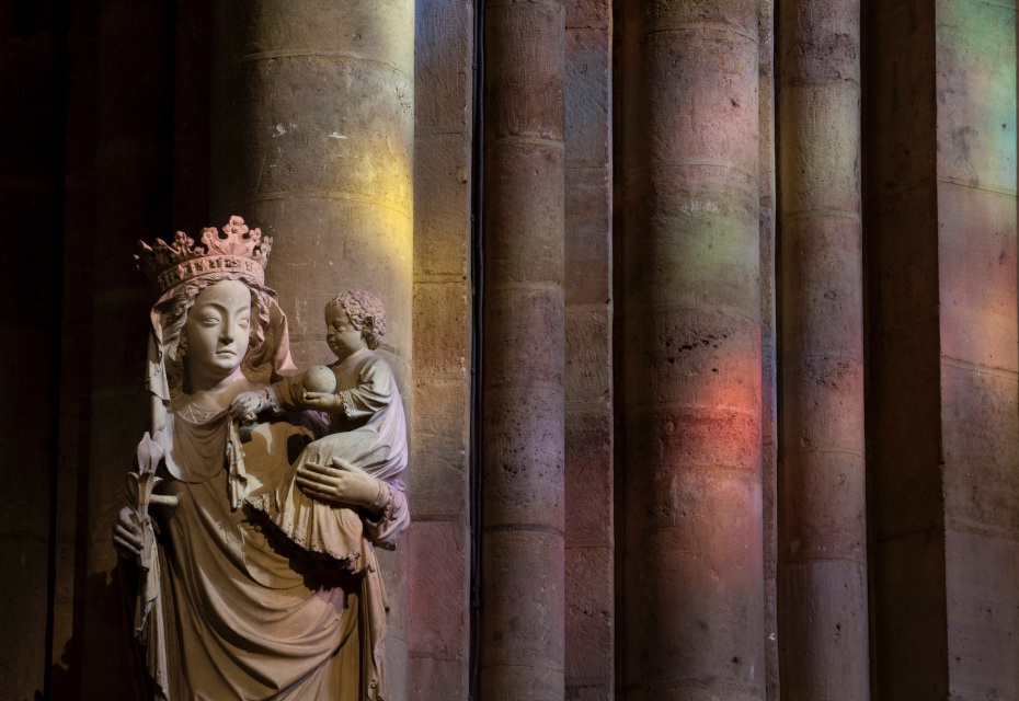 Statue de la Vierge à l'enfant baignée dans les couleurs reflétées par les vitraux